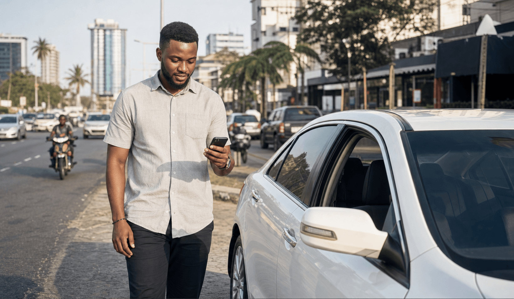 A rider checking a phone beside a car before starting a trip
